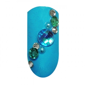 Svetlo modrý uv gél nechajte stvrdnúť v uv lampe. Potom na necht vsaďte veľký 5 mm kamienok a okolo neho poukladajte ďalšie menšie tyrkysové kamienky a perličky. 